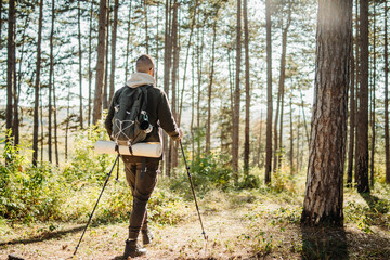 Young caucasian man hiking or trekking through the forest	