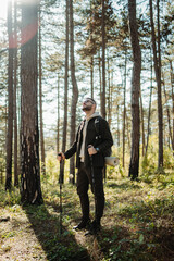 Fototapeta premium Young caucasian man hiking or trekking through the forest 