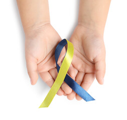 Child with yellow and blue ribbon on white background, top view. Down syndrome awareness