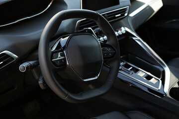 Steering wheel and dashboard inside of modern luxury car, closeup