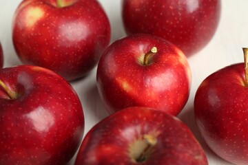 Fresh ripe red apples on white wooden table, closeup