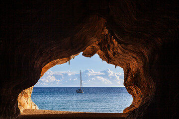 Cala Luna beach. Sardinia. Italy. Beautiful Mediterranean sea view with sailboat from the cave at...