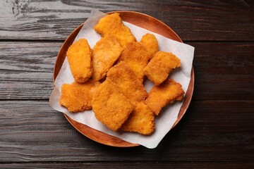 Tasty chicken nuggets on wooden table, top view