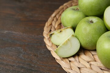 Whole and cut green apples on wooden table, closeup. Space for text