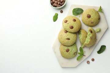 Delicious mint chocolate chip cookies on white table, flat lay. Space for text