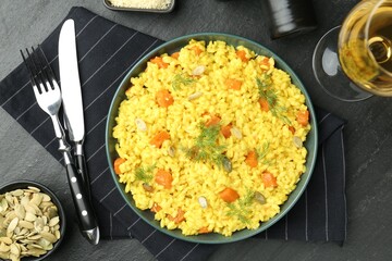 Delicious pumpkin risotto served on black table, flat lay