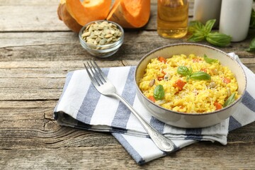 Delicious pumpkin risotto served on wooden table. Space for text