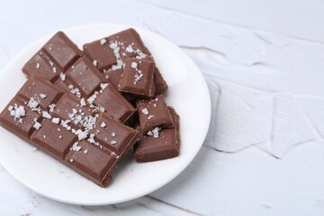 Pieces of chocolate with salt on white table