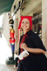 Young happy woman with a gift in her hands on the background of a Christmas gift shop. The concept of holiday shopping. Part of a series