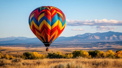 Naklejka premium Colorful Tribal Patterned Hot Air Balloon in Scenic Landscape
