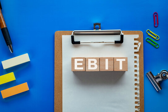 There is wood cube with the word EBIT. It is an abbreviation for Earnings Before Interest and Taxes as eye-catching image.