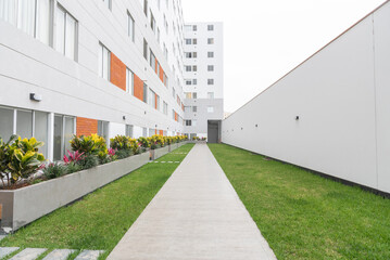 jardin patio interno de edificio de departamento con areas verdes y camino 