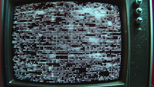 A vintage television screen displays a static pattern of white dots on a black background