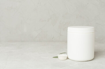 Jar with protein powder on concrete background. Sports nutrition concept