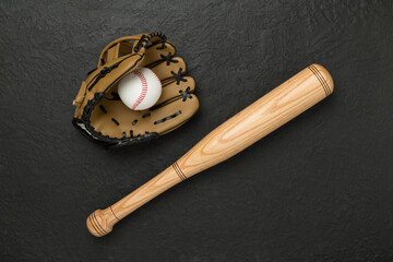 Baseball glove and bat with ball on concrete background, top view