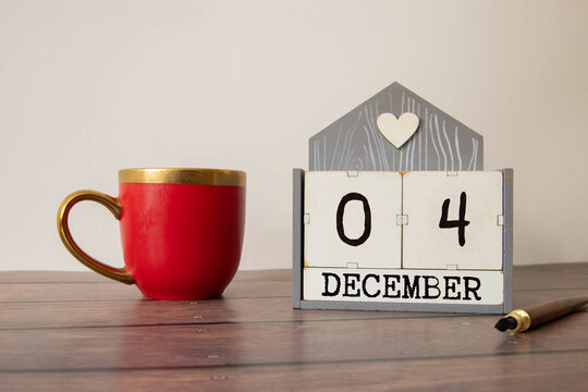 Closeup white wooden calendar with black 4 december word on black glass table
