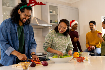 Christmas time, multiracial friends preparing festive meal together in kitchen, at home