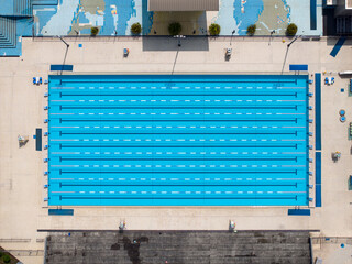 Aerial view of swimming pool with marked lanes and swimmers.