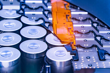 Metal parts with shiny steel cylindrical surface closeup. disassembled lithium ion form factor cell battery pack.