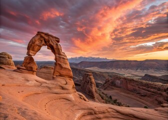Stunning Natural Arches Bathed in Warm Orange and Pink Hues at Dusk in a Majestic Landscape