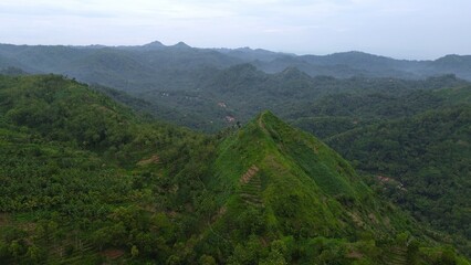 Fototapeta premium Aerial drone view of the Serayu River Dam with roads, traffic and railways beside it with hills and trees in the background
