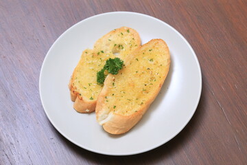 Crispy Garlic Bread on white plate. Air fryer bread with butter garlic and parsley 
