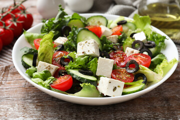 Delicious salad with feta cheese on wooden table, closeup
