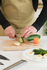A handsome man prepares breakfast in the kitchen. The guy is cooking a delicious dish