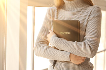 Young woman with Bible at home