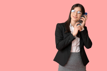 Obraz premium Young Asian woman with bottle of water on pink background
