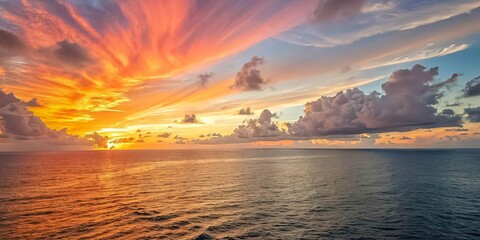 A Canvas of Crimson and Indigo A dramatic sunset paints the horizon with fiery hues, while a majestic bank of clouds looms above, casting an ethereal shadow upon the vast expanse of the ocean.