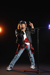 Cute little girl with microphone singing on stage