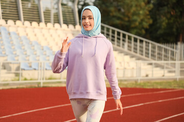 Sporty Muslim woman running at stadium