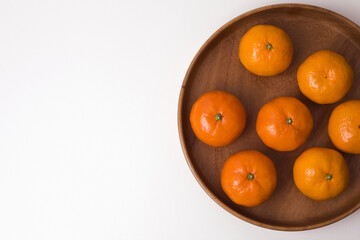 tangerines on a plate on white background