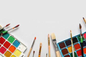 Artist brushes and paints on white background