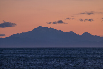 ニュージーランド　ウェリントンのレッド・ロックスのビーチから見える南島と夕焼け空