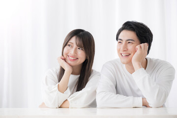 カップルで見上げる頬杖をつく男女の横顔のクローズアップ　コピースペースあり