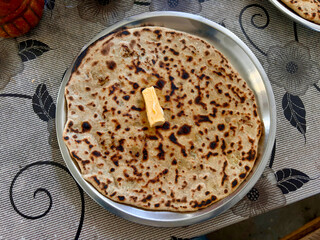 A plate of food with a piece of butter on top of it
