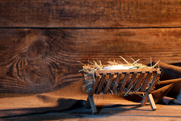 Manger with baby Jesus and cloth on wooden table