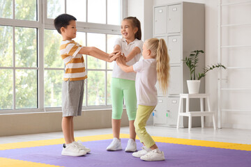 Fototapeta premium Cute little children putting hands together in gym
