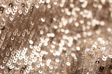 Golden wavy fabric. Textile texture with golden sequins. 