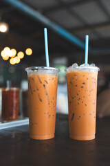 Two glasses of Thai milk tea on a wooden table. A popular drink in Thailand