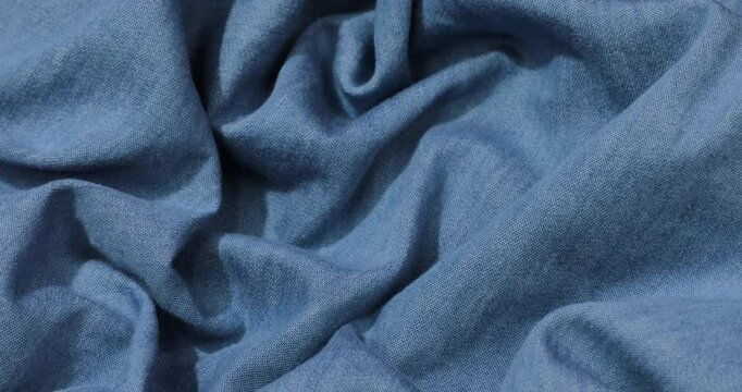 Blue denim fabric background. Blue denim cloth waves background texture. Blue denim fabric cloth textile material.