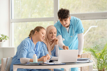 Medical students studying with laptop on table at university