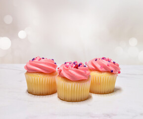 Sweet frosted pink cupcakes with sprinkles with copy space