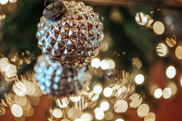 Christmas balls.Silver ball Christmas tree decoration in reflection of bokeh garlands.Beautiful...
