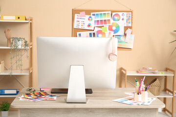 Designer's workplace with computer and color palettes in office