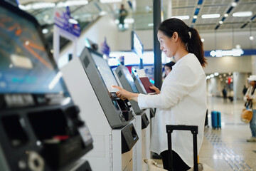 Efficient Air Travel: Woman Using Self-Service Check-In Kiosk at Airport