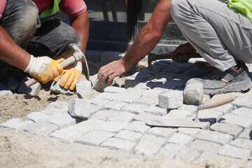 Group of Construction Workers Engaged in Laying Cobblestones on a Beautiful Pathway