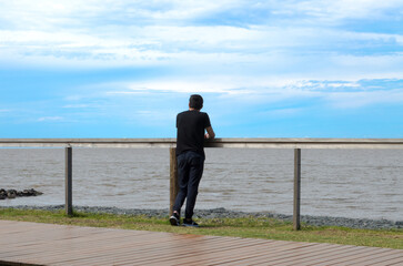 Chico observando el río de La Plata desde la reserva ecológica Costanera Sur, Buenos Aires, Argentina. 